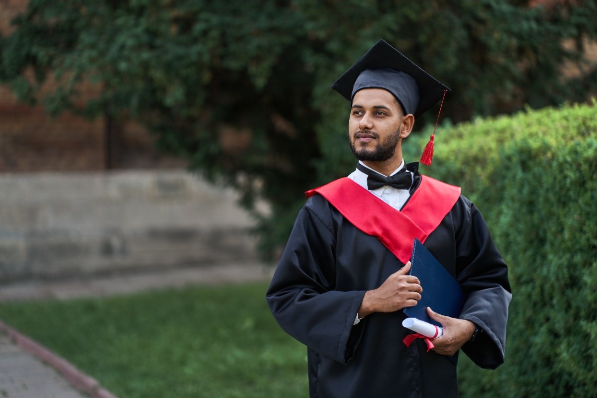 Graduate student celebrating with diploma